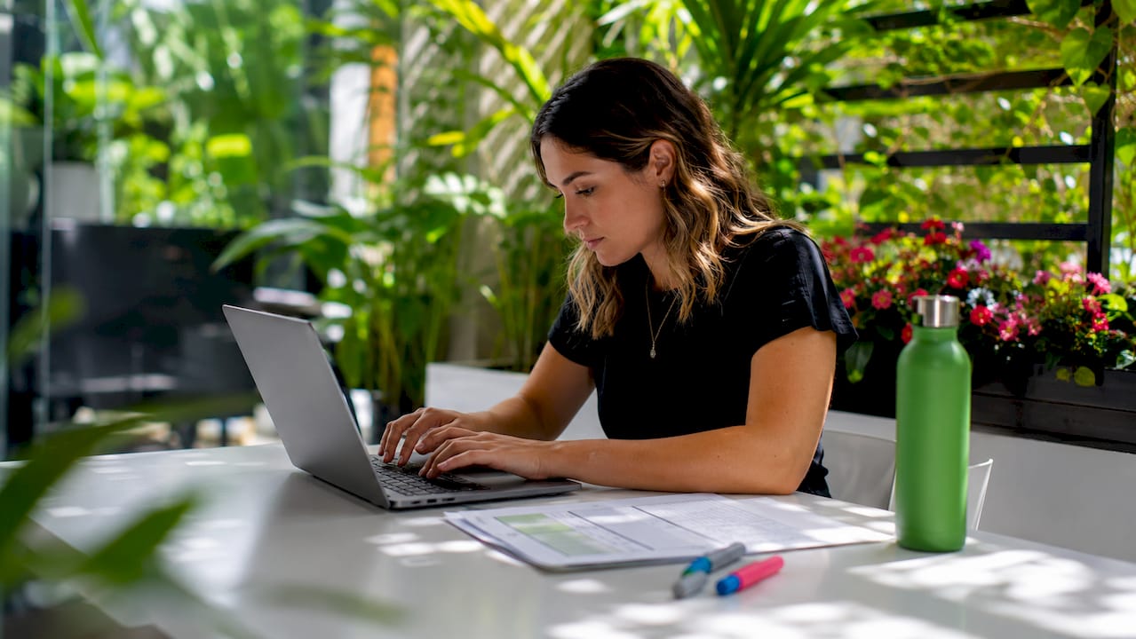 Woman typing SEO checklist at desk